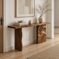 Console table with a slab top and one leg carved in flowing waves in a Scandinavian entryway with white walls