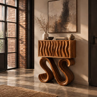 Wavy fluted console table on two large s shaped scroll legs in an industrial loft entryway with exposed brick