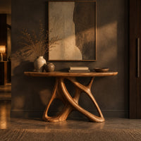 Oval console table on an open base of twisting interlocked loops in a dark entryway at golden hour