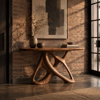 Oval console table on an open base of twisting interlocked loops in an industrial loft entryway with exposed brick