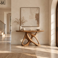Oval console table on an open base of twisting interlocked loops in a bright open plan entryway