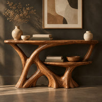 Corner detail of wooden console table with a branching root base and a small lower shelf beside wood, brass and linen samples
