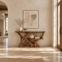 Wooden console table with a branching root base and a small lower shelf in a bright open plan entryway