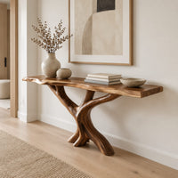 Console table with a thin natural edge top on a branching trunk base in a Scandinavian entryway with white walls