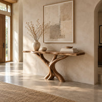 Console table with a thin natural edge top on a branching trunk base in a bright open plan entryway