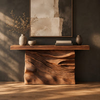 Console table with a solid block base carved in dune ripples in a dark studio against a charcoal plaster wall