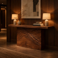 Console table with a thick plank top and wave carved block base in an evening entryway with walnut wall paneling