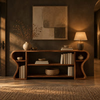 Open shelf console table with wavy curved ends and a divided center bay in a dark entryway at golden hour