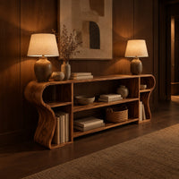 Open shelf console table with wavy curved ends and a divided center bay in an evening entryway with walnut wall paneling