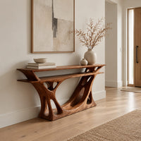 Console table with a double layer top and a branching open base in a Scandinavian entryway with white walls
