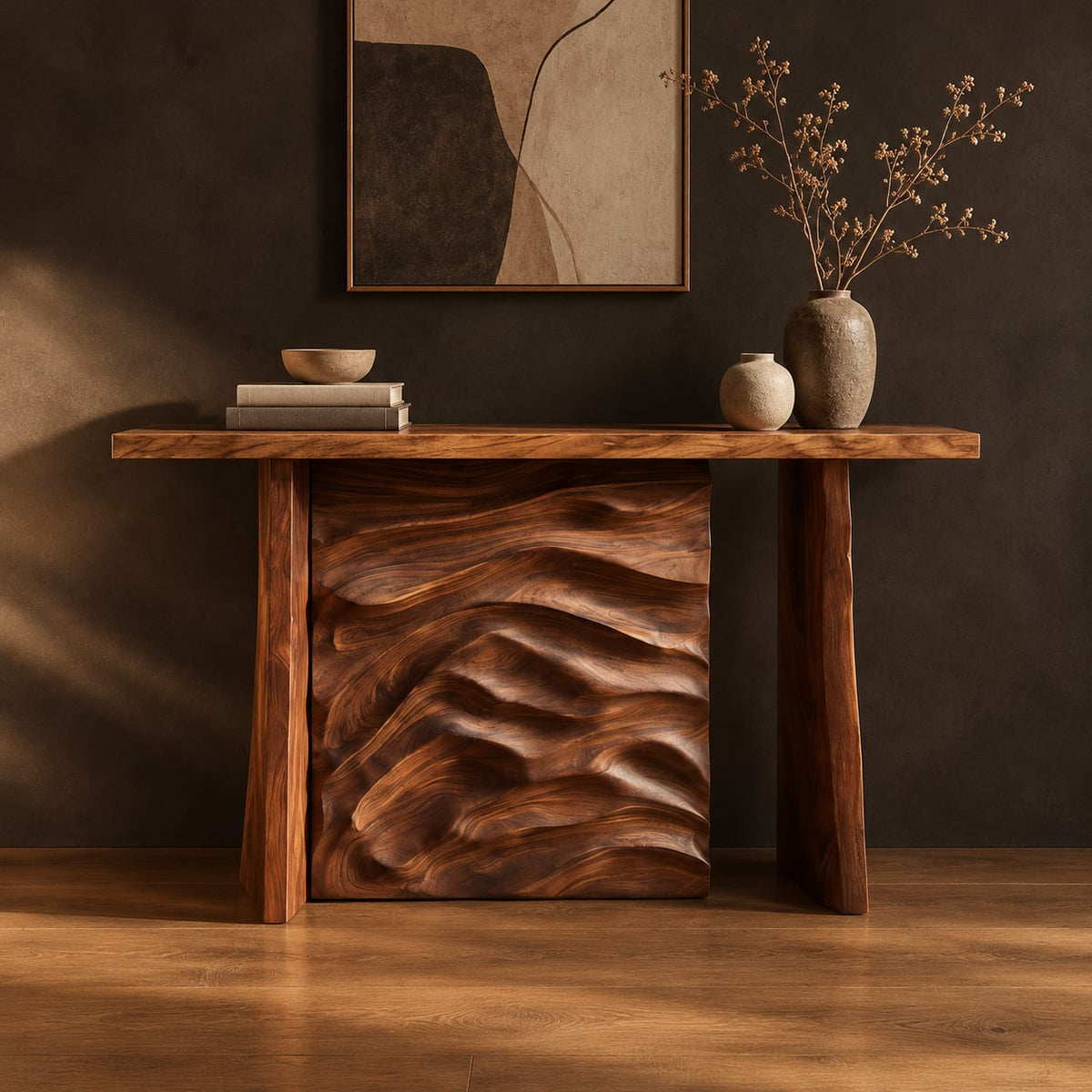 Console table with plank legs and a dune carved panel in a dark studio against a charcoal plaster wall