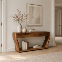 Console table with flared sculpted sides, a low shelf and two drawers in a Scandinavian entryway with white walls