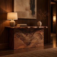 Console table with flowing carved grain front and raw edge top in an evening entryway with walnut wall paneling