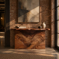 Console table with flowing carved grain front and raw edge top in an industrial loft entryway with exposed brick
