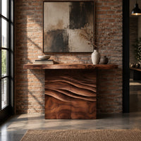 Console table with a thick top on a wave carved block base in an industrial loft entryway with exposed brick