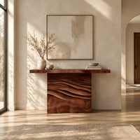 Console table with a thick top on a wave carved block base in a bright open plan entryway