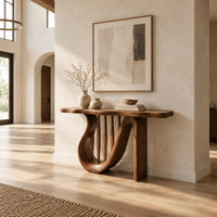 Console table with a looping curved base and tapered spindles under the top in a bright open plan entryway