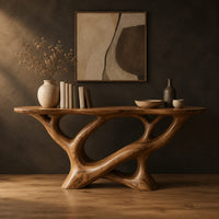 Oval top console table on a sculpted base of looping open limbs in a dark studio against a charcoal plaster wall