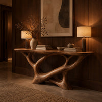 Oval top console table on a sculpted base of looping open limbs in an evening entryway with walnut wall paneling