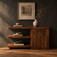 Console table with open shelves and a two door cabinet in a dark studio against a charcoal plaster wall