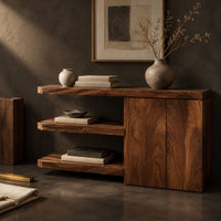 Corner detail of console table with open shelves and a two door cabinet beside wood, brass and linen samples