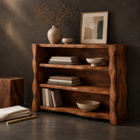 Corner detail of open shelf console table with thick wavy edged side panels beside wood, brass and linen samples