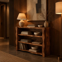 Open shelf console table with thick wavy edged side panels in an evening entryway with walnut wall paneling
