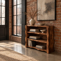 Open shelf console table with thick wavy edged side panels in an industrial loft entryway with exposed brick