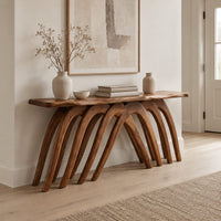 Wooden console table with a wavy top on a row of arched legs in a Scandinavian entryway with white walls