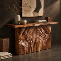 Corner detail of console table on a block base carved with rippled ridges beside wood, brass and linen samples