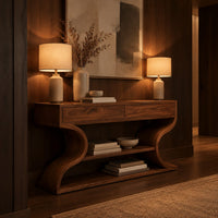 Console table with s shaped side supports and a lower shelf in an evening entryway with walnut wall paneling