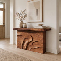 Console table on a solid base carved with flowing relief in a Scandinavian entryway with white walls