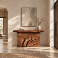 Console table on a solid base carved with flowing relief in a bright open plan entryway