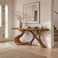 Console table with swooping left leg, crossed branch legs and natural edge top in a Scandinavian entryway with white walls