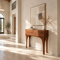 Console table with slim tapered legs and a boxy two panel top in a bright open plan entryway