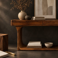 Corner detail of console table with a thick top and an open loop frame base beside wood, brass and linen samples
