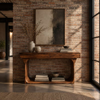 Console table with a thick top and an open loop frame base in an industrial loft entryway with exposed brick