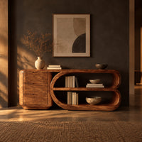 Console table with a three drawer block and a looped open shelf unit in a dark entryway at golden hour