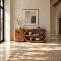 Console table with a three drawer block and a looped open shelf unit in a bright open plan entryway