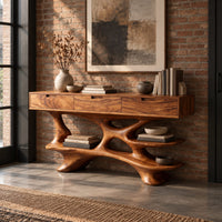 Console table with three drawers over a sculpted branching base with shelves in an industrial loft entryway with exposed brick