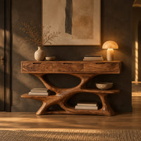 Console table with three drawers over a twisting open loop base and low shelf in a dark entryway at golden hour