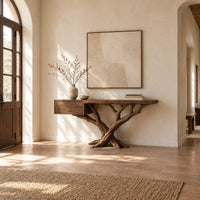 Console table with a twisting branch base and a drawer unit at one end in a bright open plan entryway