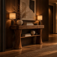 Console table with two waisted sculpted legs and a single open shelf below in an evening entryway with walnut wall paneling