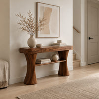 Console table with two waisted sculpted legs and a single open shelf below in a Scandinavian entryway with white walls