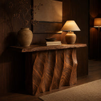 Console table with a wave carved fluted base and a live edge top in an evening entryway with walnut wall paneling