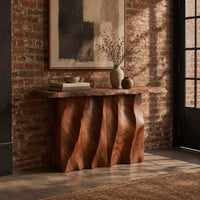 Console table with a wave carved fluted base and a live edge top in an industrial loft entryway with exposed brick