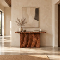 Console table with a wave carved fluted base and a live edge top in a bright open plan entryway