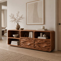 Console table with wave carved front panels and open cubbies in a Scandinavian entryway with white walls