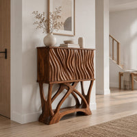 Tall cabinet with carved wavy fronts on a base of branching crossed legs in a Scandinavian entryway with white walls