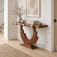 Wood console table with a wavy edge top on a layered arc base in a Scandinavian entryway with white walls